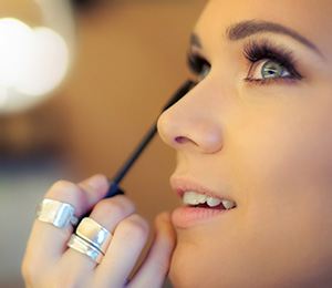 Woman having mascara applied