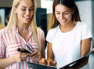 Two women looking at notebook