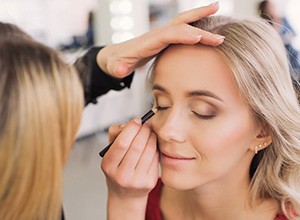 Woman having eye makeup applied