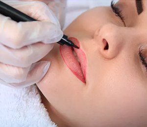 Woman having permanent makeup applied to lips